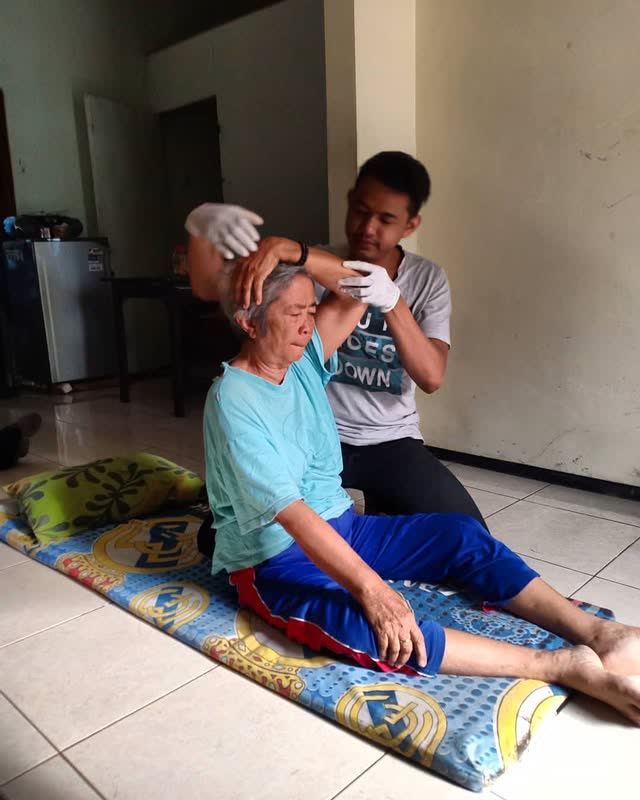 Neck alignment for an older client seated on a mat at home